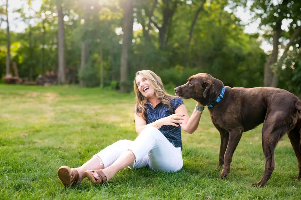 Holly laughing with her chocolate Lab